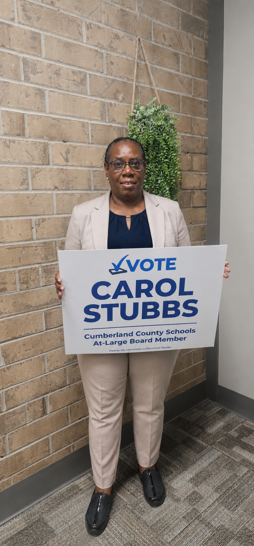 Carol Stubbs holding a Vote Carol Stubbs campaign sign